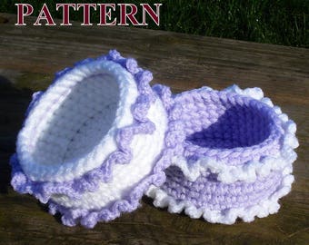 Puede incluir: Dos cestas de ganchillo con un diseño blanco y morado. Las cestas están hechas con un punto texturizado y tienen un borde rizado.