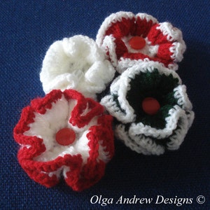May include: Four crocheted flowers in red, white, and green. Each flower has a white center with a red button in the middle.
