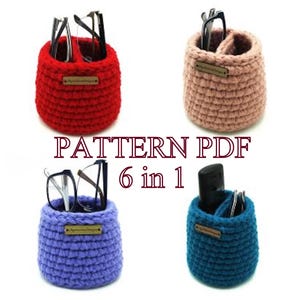 May include: Four crocheted eyeglass holders in red, pink, blue, and teal. Each holder is cylindrical with a small wooden tag. The text "PATTERN PDF 6 in 1" is displayed in the center of the image.