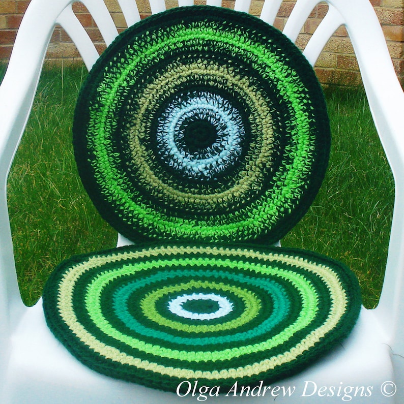 May include: Two crocheted round chair cushions in shades of green, beige, and white. The cushions have a concentric circle pattern.