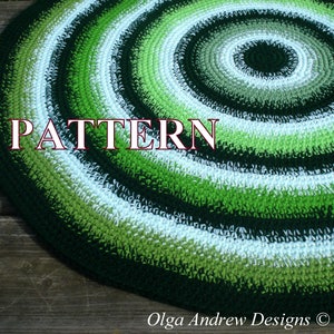 May include: A crochet rug with a circular pattern in shades of green and white. The rug has a center circle with a dark green color that gradually transitions to lighter shades of green and white as it moves outward. The word "PATTERN" is written in red letters across the center of the rug.