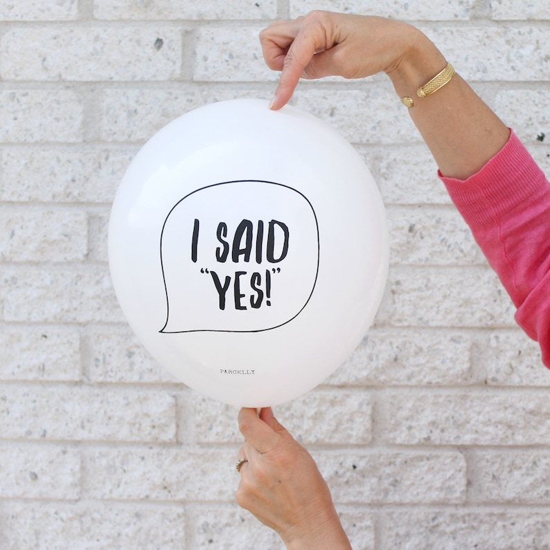 May include: White balloon with black text that says "I said "YES!" in a speech bubble.