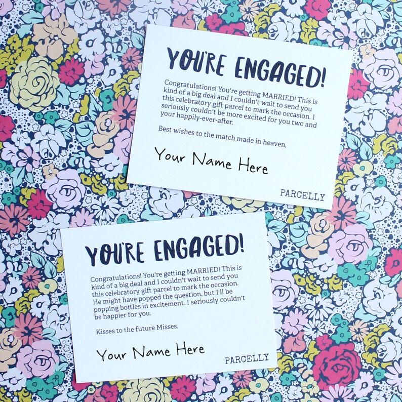 May include: Two white cards with a floral background. The cards have the text "You're Engaged!" and a message congratulating the couple on their engagement. The cards also have the text "Your Name Here" and "Parcellly".