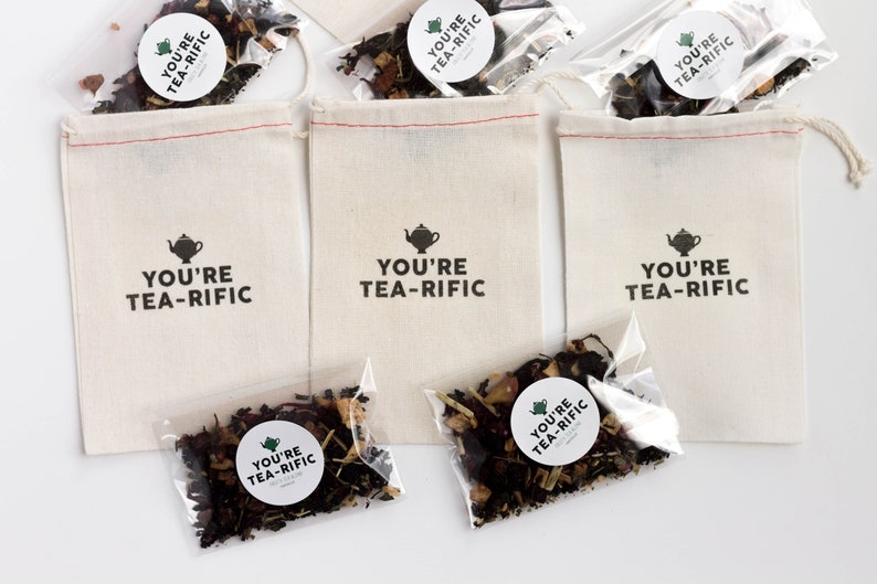 May include: Three white cotton drawstring bags with the text "You're Tea-Rific" printed on them. Each bag contains a small clear plastic bag filled with loose leaf tea.