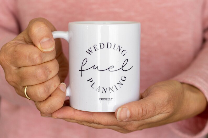 May include: White ceramic mug with black text that reads "Wedding Fuel Planning" in a circle. The text "Parchelly" is printed below the circle.