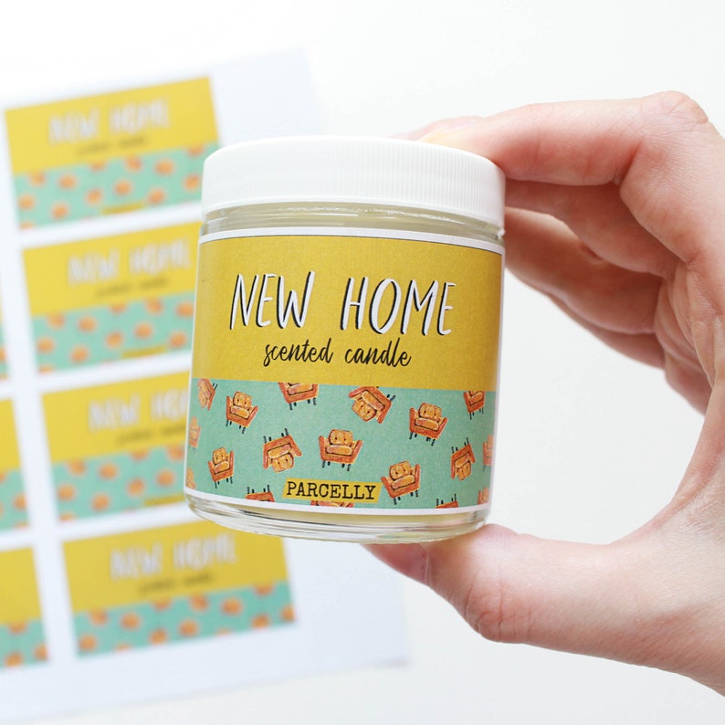 May include: A white candle jar with a yellow label that says "NEW HOME scented candle" and a pattern of orange armchairs on a teal background. The label also says "PARCELLY".