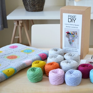 Può includere: Un kit per lavorare all'uncinetto una coperta a quadrati granny. Il kit include filato di vari colori, tra cui grigio, azzurro, rosa, verde, giallo e arancione. Il kit include anche un uncinetto e le istruzioni.