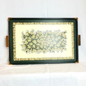 May include: A black serving tray with a gold trim and a floral design. The tray has a white background with a green and yellow floral pattern.