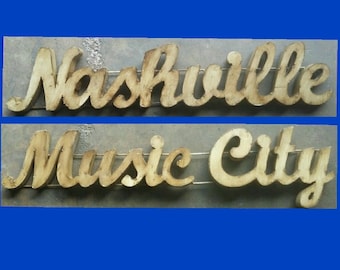 May include: A rustic metal sign with the words "Nashville Music City" in a distressed, white paint finish. The sign is perfect for adding a touch of Southern charm to your home decor.
