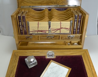 May include: An antique wooden writing desk with multiple compartments, drawers, and a hinged lid. The desk features a burgundy velvet writing surface, a calendar, and a small framed "ENGAGEMENTS" board. It includes a ruler, scissors, and other writing tools.