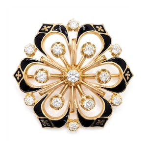 May include: A gold-toned brooch with a floral design. The brooch features black enamel accents and is adorned with numerous clear, sparkling gemstones. The design is symmetrical, with a central gemstone and radiating petals.