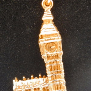 May include: A gold charm necklace featuring a detailed replica of Big Ben, the iconic clock tower in London, England.
