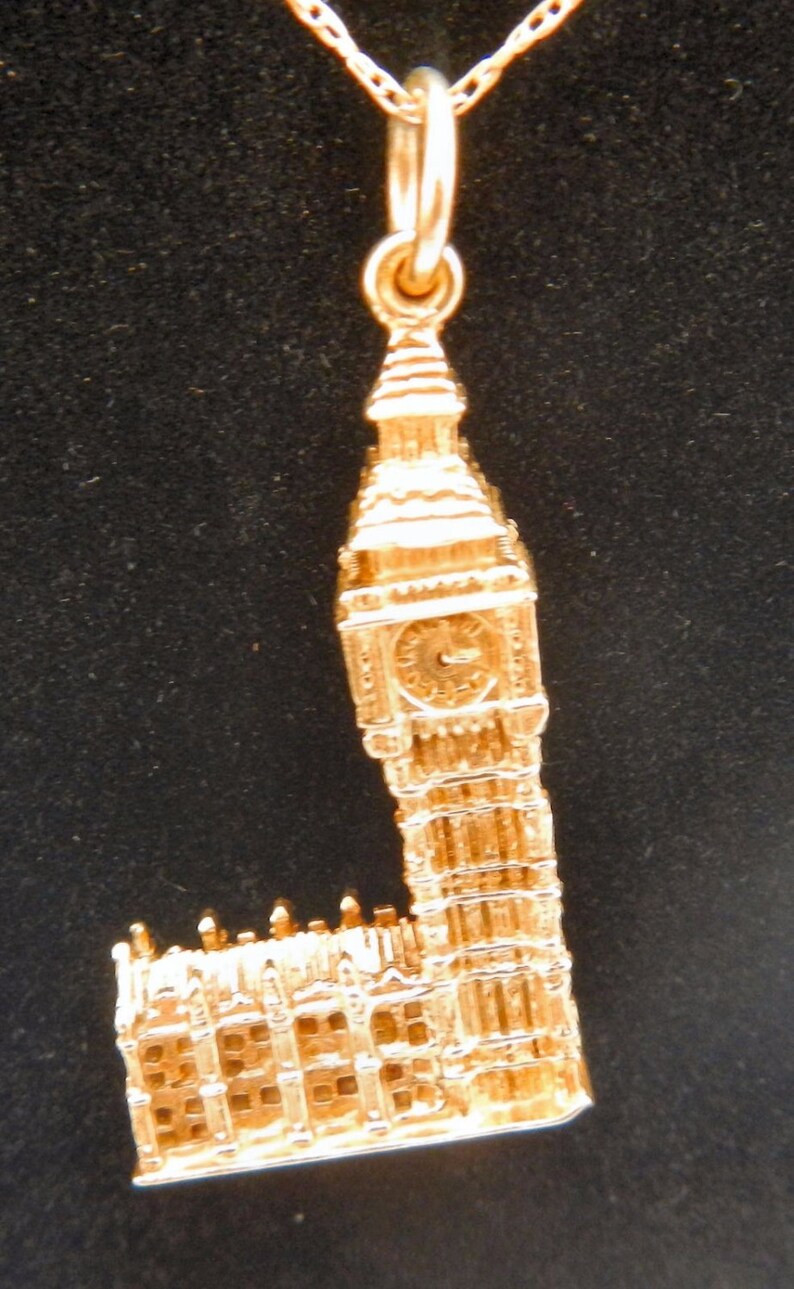 May include: A gold charm necklace featuring a detailed replica of Big Ben, the iconic clock tower in London, England.