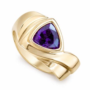 May include: A gold ring featuring a triangular, deep purple gemstone. The ring has a smooth, polished finish with a modern, sculptural design. The gemstone is set in a bezel setting, enhancing its vibrant color and shape.
