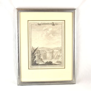 May include: A framed black and white engraving of Niagara Falls. The engraving is titled "Carta di Niagara" and shows a view of the falls from a distance. The engraving is surrounded by a silver frame.