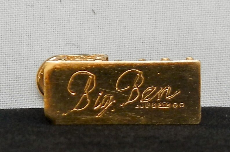 May include: Gold-colored metal charm with the inscription "Big Ben" and the date "July 9, 1993" engraved on the front.