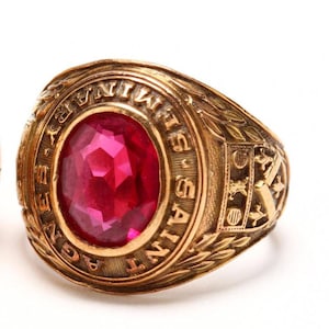 May include: A gold class ring with a red gemstone and the inscription "SAINT  MARY'S  AGNES  1947".