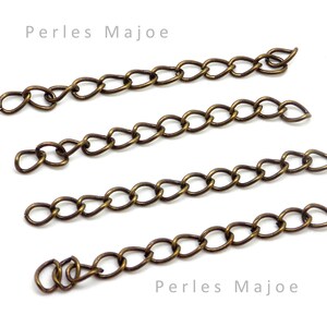 Peut inclure: Quatre chaînes dorées, chacune d'une longueur différente. Les chaînes sont composées de petits ovales liés. Le texte "Perles Majoe" apparaît deux fois sur l'image.