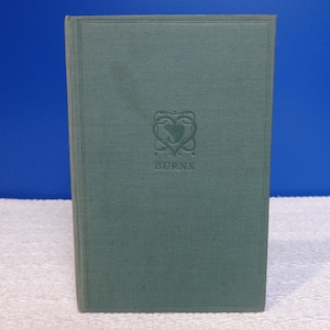 May include: A teal-coloured vintage book. The cover has an embossed design with a heart shape and the name "BURNS" beneath it. The book is upright against a blue backdrop.