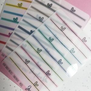 May include: A set of six transparent sticker sheets with pastel colored lines and hearts. The sticker sheets are labeled "Heart Divider (Weeks) - Transparent - Pastel" and "Josephine Bow".