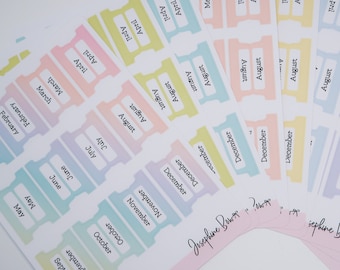 Puede incluir: Una colección de pegatinas de planificador en colores pastel con los meses del año impresos. Las pegatinas son en tonos de rosa, amarillo, azul y morado. El nombre "Josephine Bows" está escrito en algunas pegatinas.