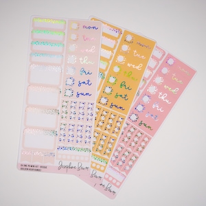 Puede incluir: Un conjunto de tres hojas de pegatinas de planificador rosas, amarillas y azules con los días de la semana escritos en una fuente manuscrita. Las pegatinas presentan una variedad de formas y tamaños, incluyendo círculos, cuadrados y rectángulos. Las pegatinas están decoradas con un acabado brillante.