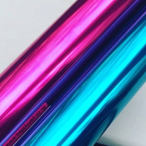 May include: Two rolls of metallic vinyl wrap, one pink and one blue. The rolls are partially overlapping, showing the color of the vinyl underneath. The text "www.beverlywax.co.uk" is visible on the bottom left corner of the image.