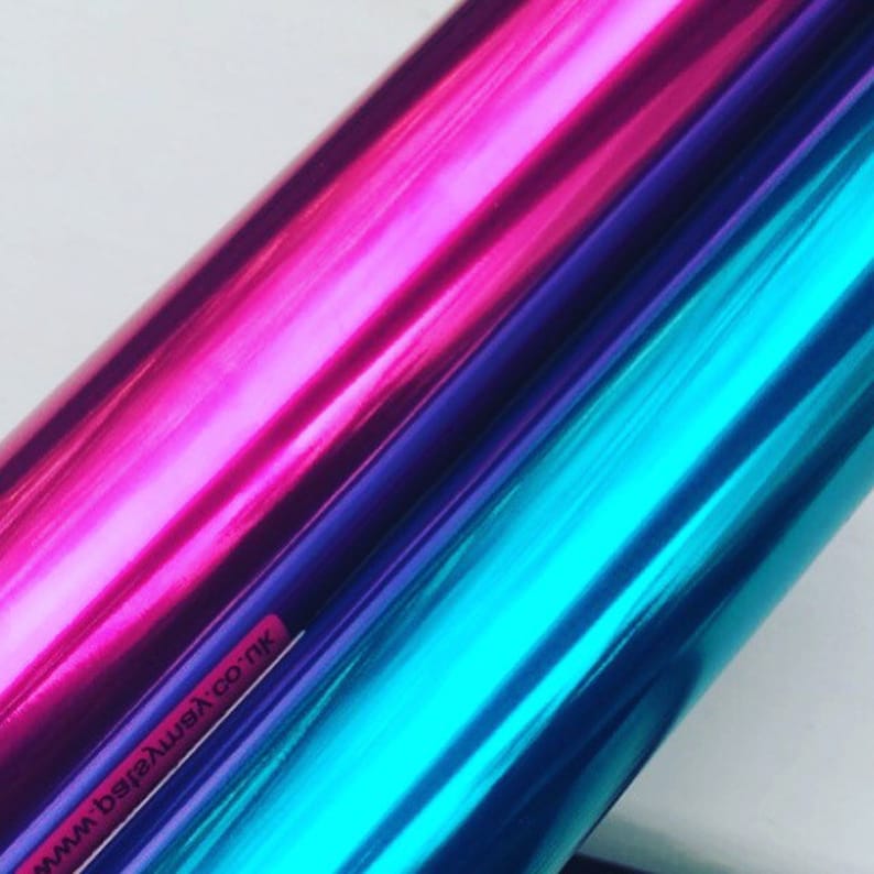 May include: Two rolls of metallic vinyl wrap, one pink and one blue. The rolls are partially overlapping, showing the color of the vinyl underneath. The text "www.beverlywax.co.uk" is visible on the bottom left corner of the image.