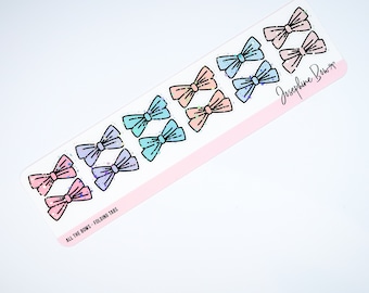 Può includere: Un foglio di linguette pieghevoli con disegni di fiocchi colorati in tonalità pastello di rosa, blu e viola. Le linguette hanno un effetto glitterato e sono etichettate "ALL THE BOWS - FOLDING TABS" e "Josephine Bows".
