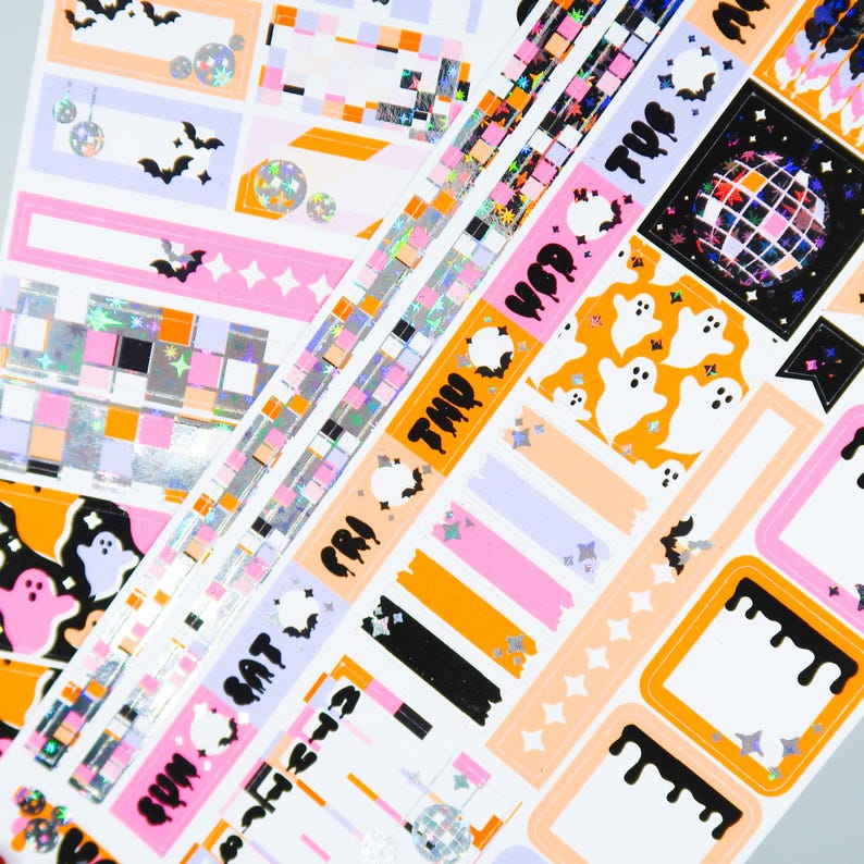 May include: A set of Halloween themed planner stickers with a variety of designs including ghosts, bats, and disco balls. The stickers are on a white background with orange, pink, and purple accents.