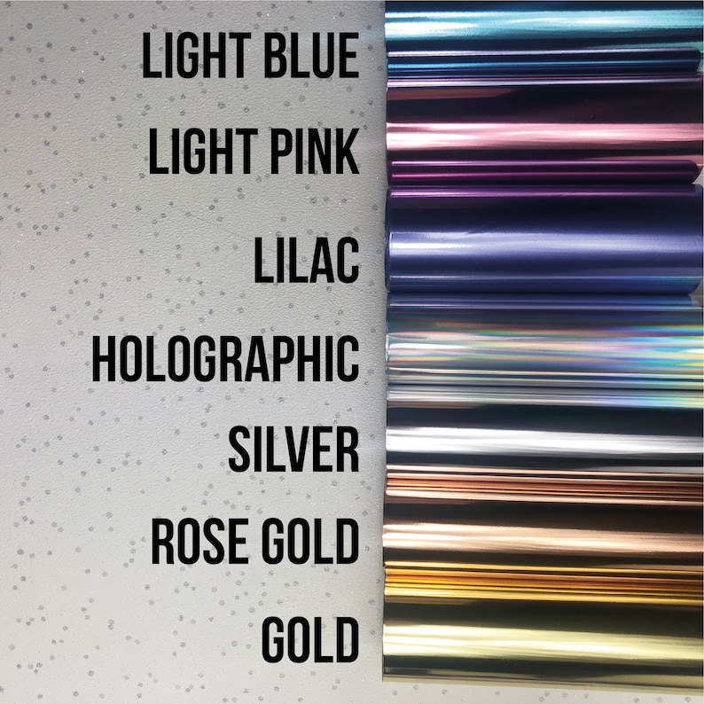 May include: A close-up of seven different colored rolls of vinyl adhesive. The colors are light blue, light pink, lilac, holographic, silver, rose gold, and gold.