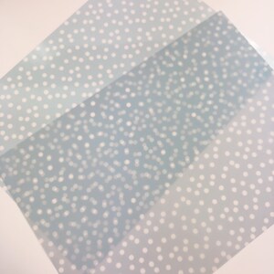 Op de afbeelding: Drie vellen blauw gestreept cadeaupapier met witte stippen. De stippen zijn van verschillende grootte en zijn willekeurig gerangschikt. Het papier is doorschijnend en heeft een subtiele glans.