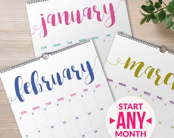 May include: Three wall calendars with spiral binding featuring the months of January in pink, February in blue, and March in gold. Each page displays a grid of days with the text START ANY MONTH printed on a circular white overlay.