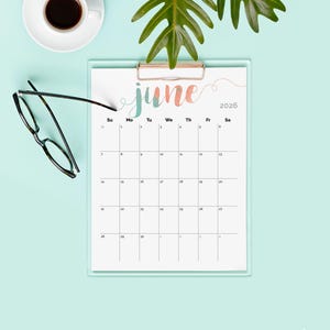 May include: A clipboard calendar for June 2026 with a watercolor-style "June" header in teal and coral. The calendar is on a light blue background, with a cup of coffee, glasses, and a green plant.
