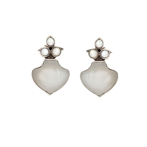 Puede incluir: Un par de pendientes de plata con detalles de perlas blancas. Los pendientes tienen un diseño en forma de lágrima con un grupo de tres perlas en la parte superior.
