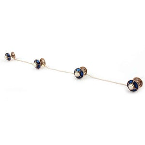 May include: A set of four blue and white enamel cufflinks with a pearl centre. The cufflinks are connected by a chain.