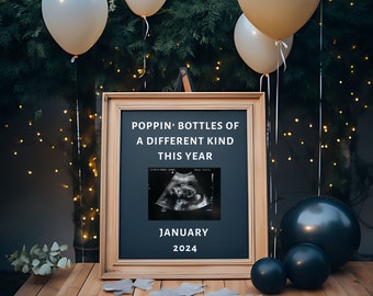 May include: A framed chalkboard sign with the text "Poppin' Bottles of a Different Kind This Year" and a black and white ultrasound image. The sign also includes the text "January 2024". The sign is surrounded by white and black balloons.