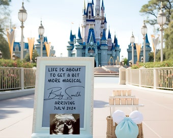 May include: A white sign with the text "Life is about to get a bit more magical" and "Baby Smith Arriving July 2024". The sign is in front of Cinderella's Castle at Walt Disney World.