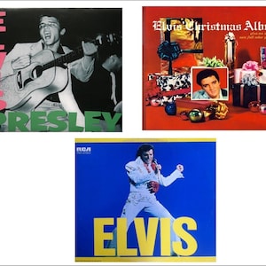Puede incluir: Tres portadas de discos de vinilo diferentes con Elvis Presley. La primera portada es negra con un texto "ELVIS" rosa y un texto "PRESLEY" verde. La segunda portada es roja con un texto "Elvis Christmas Album" blanco y una imagen de Elvis Presley rodeado de regalos de Navidad. La tercera portada es azul con un texto "ELVIS" amarillo y una imagen de Elvis Presley con un traje blanco.