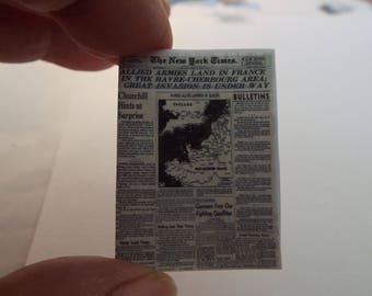 May include: A black and white newspaper clipping from The New York Times, dated June 6, 1944, with the headline "Allied Armies Land in France in the Havre-Cherbourg Area: Great Invasion is Under Way". The article includes a map of England and the Normandy region of France.