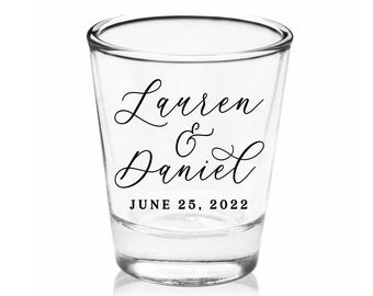 May include: Clear glass shot glass with black calligraphy that reads "Lauren & Daniel" and "JUNE 25, 2022".