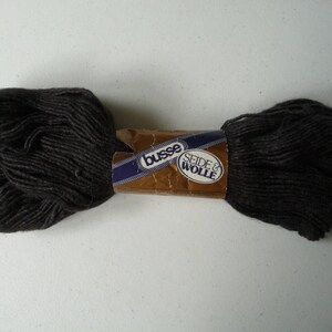 May include: A skein of dark brown yarn with a label that reads "Busse Seide & Wolle".