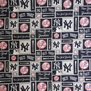 May include: A black and white fabric with a repeating pattern of the New York Yankees logo, baseball bats, and baseballs. The fabric has a gray background and the pattern is in a grid format.