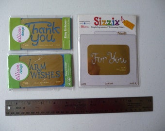 May include: Four craft items are displayed: two green and gold "Thank You" and "Warm Wishes" cards, an embossing folder with "For You" text, and a ruler. The cards have blue text and are from Ellison Design. The Sizzix embossing folder is in a clear plastic package.