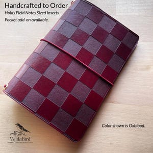 May include: A rectangular leather journal cover in an oxblood checkerboard pattern with a thin elastic closure band. Text on the image reads: Handcrafted to Order, Holds Field Notes Sized Inserts, Pocket add-on available, Color shown is Oxblood.