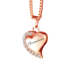 Puede incluir: Collar con colgante en forma de corazón de oro rosa con detalles de cristal transparente y la palabra "Abuela" grabada en la parte delantera.