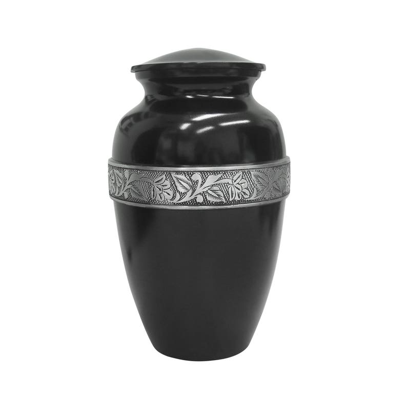 May include: Black urn with a silver floral design around the middle.
