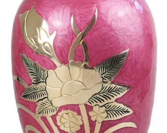 May include: A pink and gold urn with a floral design. The urn is made of brass and has a glossy finish.