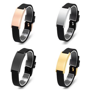 Könnte beinhalten: Vier Silikonarmbänder mit Metallplatten. Die Platten sind in vier verschiedenen Farben: Roségold, Silber, Schwarz und Gold. Die Armbänder sind alle schwarz.
