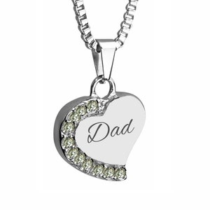 May include: Silver heart-shaped pendant necklace with a clear crystal trim and the word "Dad" engraved on the front.